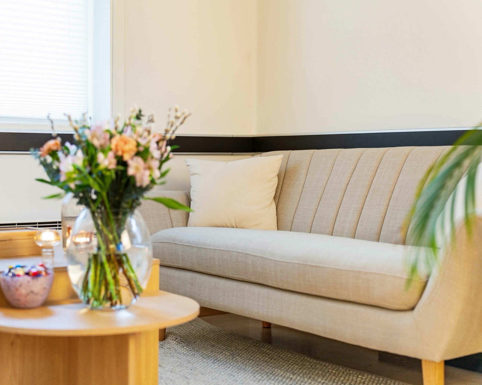 Venterommet på Stavanger Terapihus med sofa og blomster